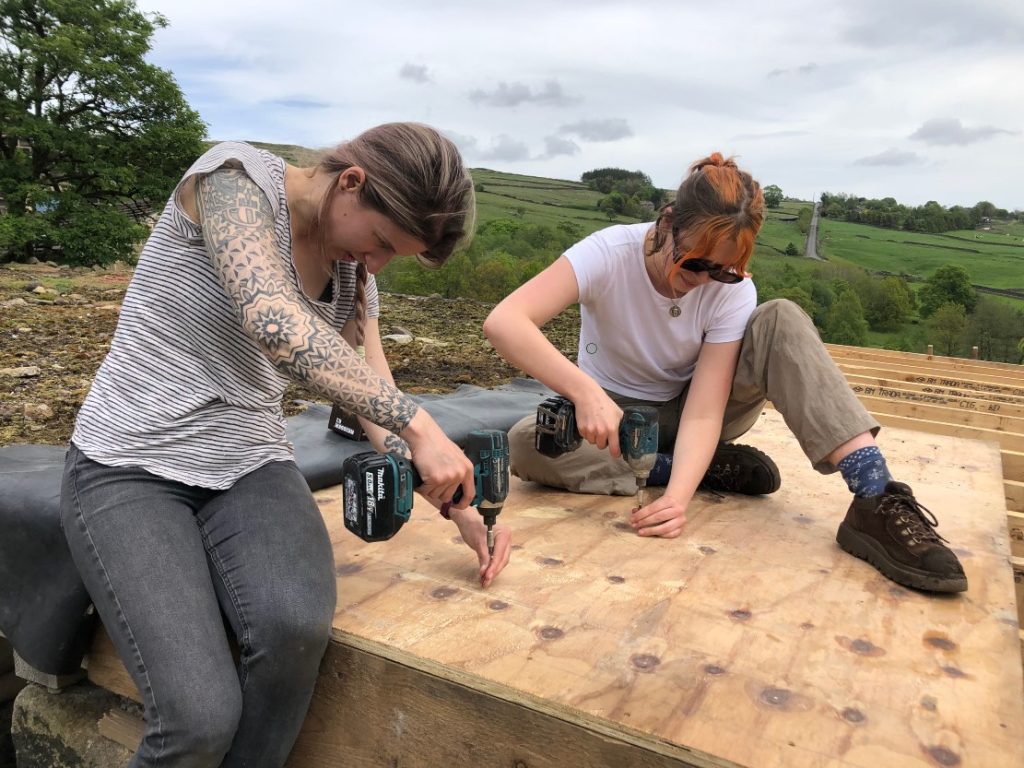 Julija and River building a roof